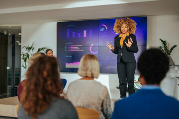 Businesswoman talking on stage in business conference.