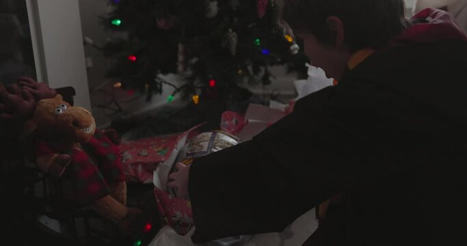 Young boy unwraps present he is really excited for on christmas morning