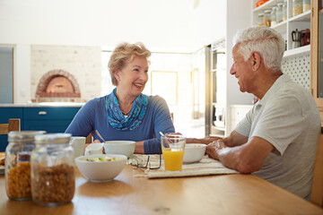 Love means making time for each other. a happy mature couple having breakfast together in their kitchen at home.
