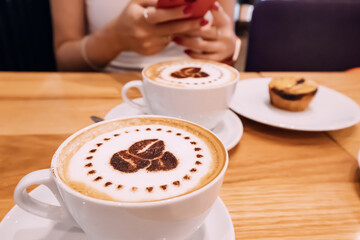 Cappucino coffee with foam and muffin cupcake on a table in cafe
