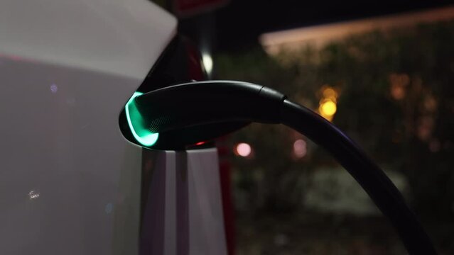 Electric car charging at night - close up on charger port
