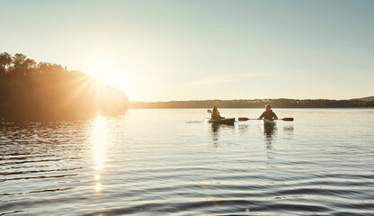 The best days are spent kayaking. a young couple kayaking on a lake outdoors.