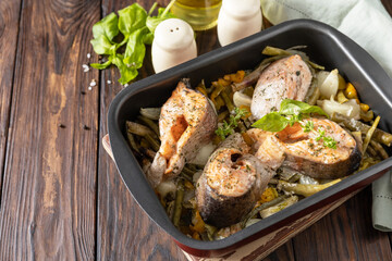 Healthy baked fish salmon steaks with basil, green beans and sweet peppers on a rustic table. Low carb dinner, healthy nutrition concept, diet menu. Copy space.