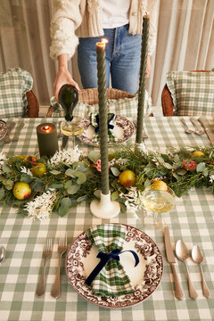 Person pouring wine at holiday table