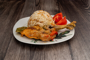 Fried chicken legs and rice in a white plate.