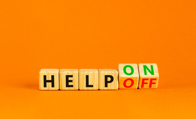 Help on or off symbol. Businessman turns wooden cubes and changes word Help off to Help on. Beautiful orange table orange background. Business and help on or off concept. Copy space.