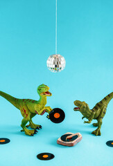 Cute green dinosaur toy holding a vinyl record and listen vinyl on vinyl record player with his...