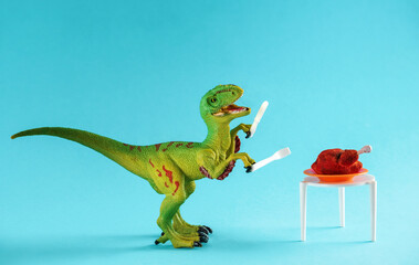 A cute little green dinosaur holds a fork and knife near a table with a roast turkey.