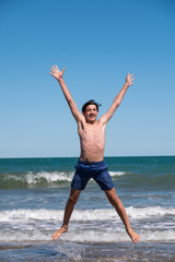 Happy boy performs pirouettes and big jumps on the seashore during his summer vacation on the Atlantic Coast, Las Grutas, Rio Negro, Argentina. © buenaventura13