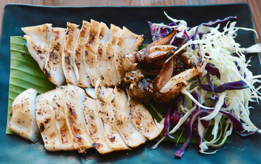 Grilled squid with vegetables on color plate