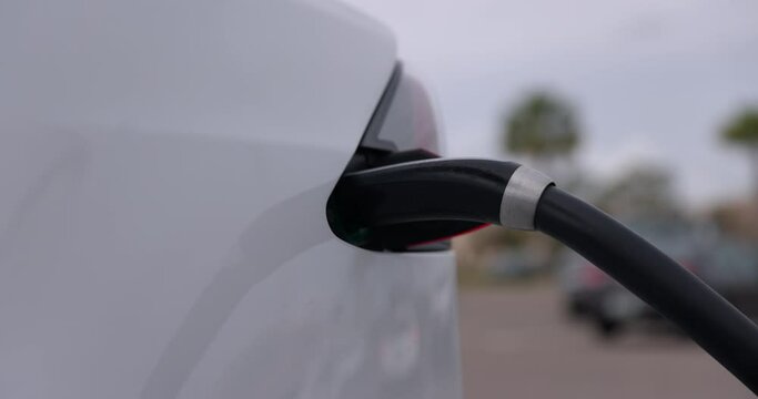 Electric charge charger in white ev car - close up on connector