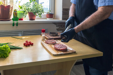 Man making hamburger patties at the table, close-up