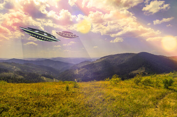 UFO, space saucer flying in the sky over high mountains. Landscape with an invasion by an extraterrestrial space object in summer