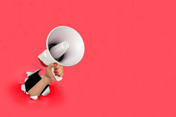 Loudhailer, hand holding megaphone breakthrough paper hole. Announcement, advertising, public hearing concept. Mockup design with loudspeaker, Torn background with blank empty space for copy space - obrazy, fototapety, plakaty