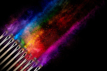 Explosion of multicolor shimmer powder dust, eye shadow, blush brushes on black background. Pigments for make-up. Abstract noisy texture background for cosmetic makeup concept