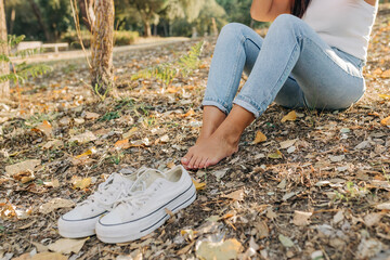 Crop barefoot woman sitting on ground