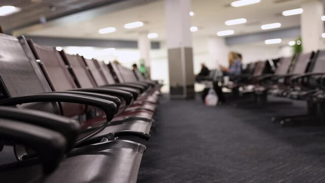 Airport gate terminal with empty seats on a sunny day - reduced flying