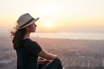 Fototapeta retrato perfil mujer joven sentada en un mirador observando un bello atardecer sobre el océano en La Serena obraz