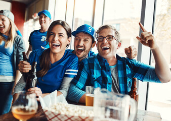 The biggest game is about to go down. a group of friends cheering while watching a sports game at a...