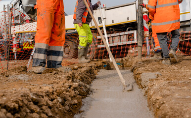 Mobile concrete pump on construction site used bybuilders pouring house foundation with wet...