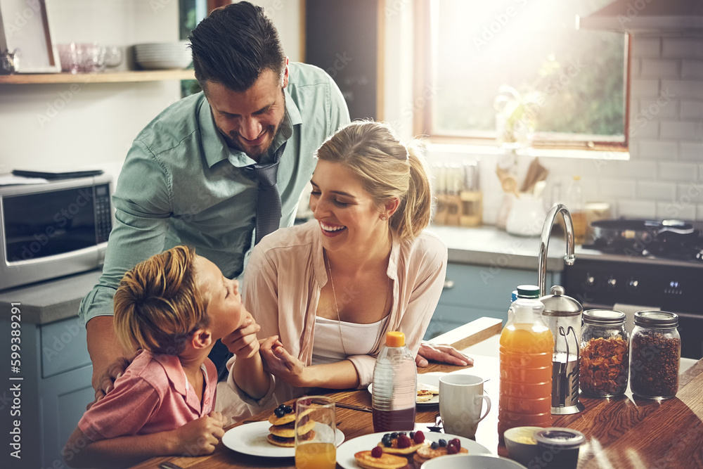 Poster hes being such a good boy. a little boy eating breakfast with his parents.