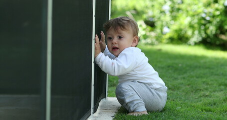 Cute baby on grass backyard. Infant observing surroundings
