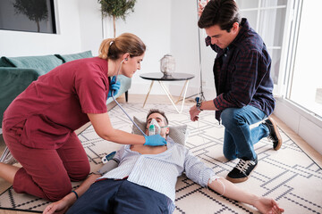 Doctor attending a vital emergency at home and performing first aid maneuvers. Concept: first aid, health care, rescue
