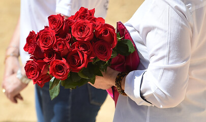 un ramo de rosas en los brazos de una mujer - 599392416