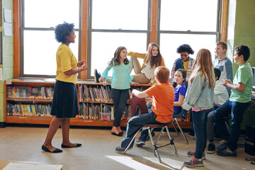 When a career and a passion comes together. a young teacher educating a group of elementary...
