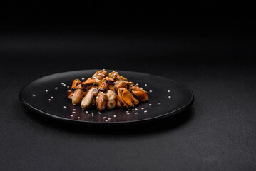 Delicious marinated mussels with spices and herbs on a ceramic plate