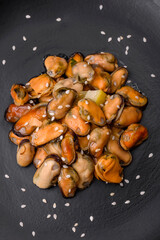 Delicious marinated mussels with spices and herbs on a ceramic plate