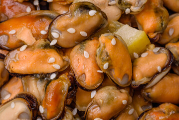 Delicious marinated mussels with spices and herbs on a ceramic plate