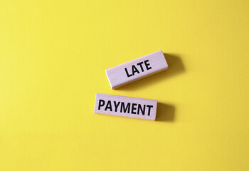Late payment symbol. Concept word Late payment on wooden blocks. Beautiful yellow background. Business and Late payment concept. Copy space