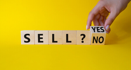 Sell Yes or No symbol. Businessman Hand turns cubes and changes words Sell No to Sell Yes. Beautiful yellow background. Business and Sell concept. Copy space