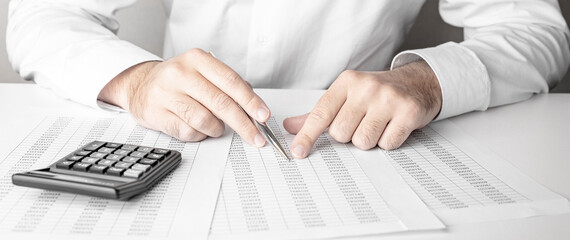 Obraz premium Businessman working with using a calculator and pen to calculate the numbers. Finance accounting concept