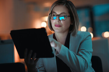 Making smart night time business moves. a businesswoman using a digital tablet during a late night...