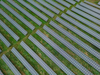 A close-up of solar panels in slow motion, as a gentle breeze ruffles their surface. The delicate movement creates a sense of tranquility and calm, and a reminder of the beauty of the natural world.