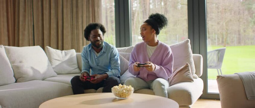 African-American Black Couple or family playing video games at home, laughing and having fun