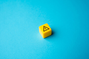 Warning sign on yellow block. Stress, problems. Something wrong. Danger or problem ahead. Careful...
