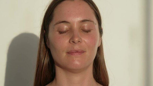 retrato de cara mujer joven caucasica con los ojos cerrados meditando en yoga estudio 