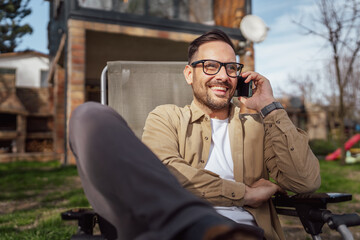 Man Talk on Smartphone in front of house Happy Smile have a phone call