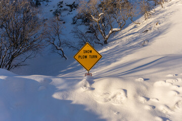 Snow plow turn sign buried in deep snow 