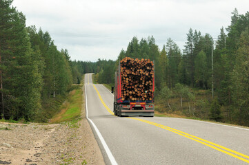 Truck Transporting Logs On A Lonely Highway Finland On An Overcast Summer Day