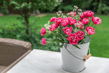 A bouquet of pink tulips in a white bucket