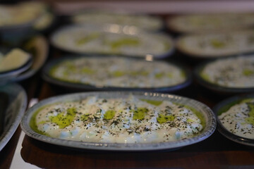 Turkish Appetizer Haydari with yogurt (Tzatziki) in white plate on wooden surface. Selective Focus. 