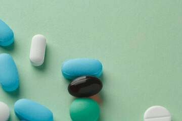 various pills on light green background, vitamins and medicine