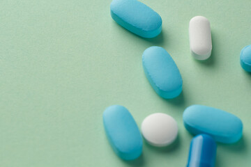 various pills on light green background, vitamins and medicine