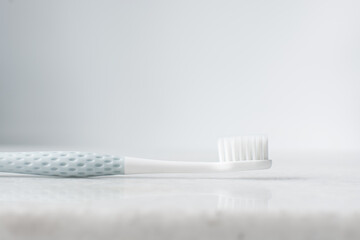 Pastel blue toothbrush with white bristles on a white background, Pastel blue toothbrush with copy space
