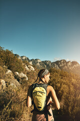Lets see whats out there to explore. Rear view shot of a young woman out on a hike through the mountains.