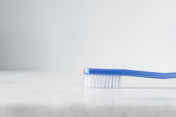 Blue toothbrush with white bristles on a white background, blue toothbrush with copy space